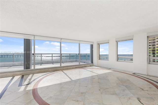 unfurnished sunroom featuring a water view