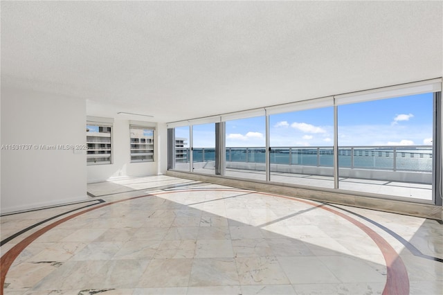 empty room with a water view and a textured ceiling