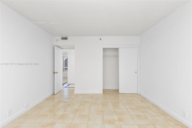 unfurnished bedroom featuring a textured ceiling and a closet