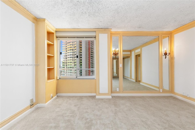 carpeted empty room featuring crown molding and a textured ceiling