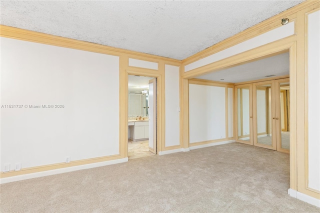 carpeted empty room with a textured ceiling and ornamental molding