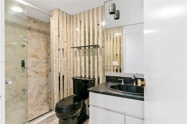 bathroom featuring vanity, a shower with shower door, and toilet