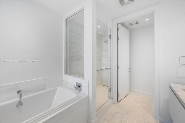 bathroom featuring tile flooring, plus walk in shower, and vanity