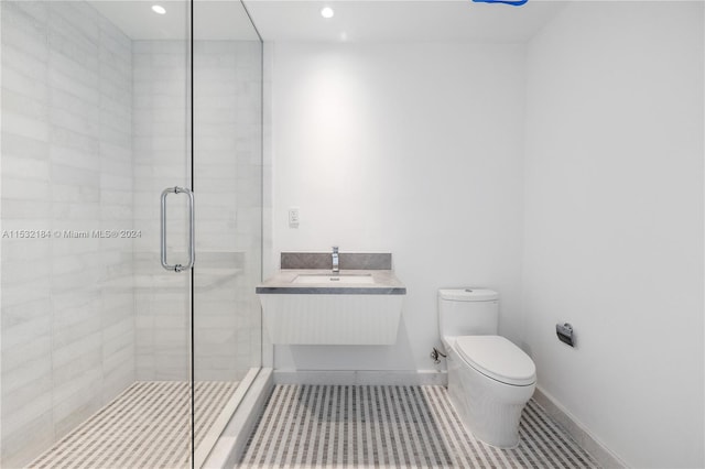 bathroom featuring toilet, tile flooring, a shower with shower door, and vanity