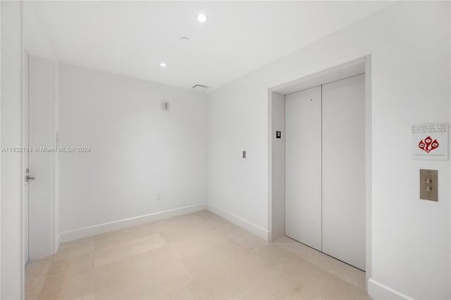 tiled spare room featuring elevator