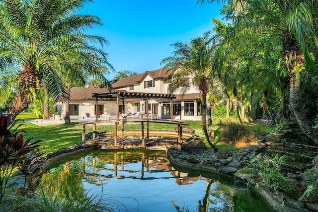 rear view of house featuring a yard and a pergola