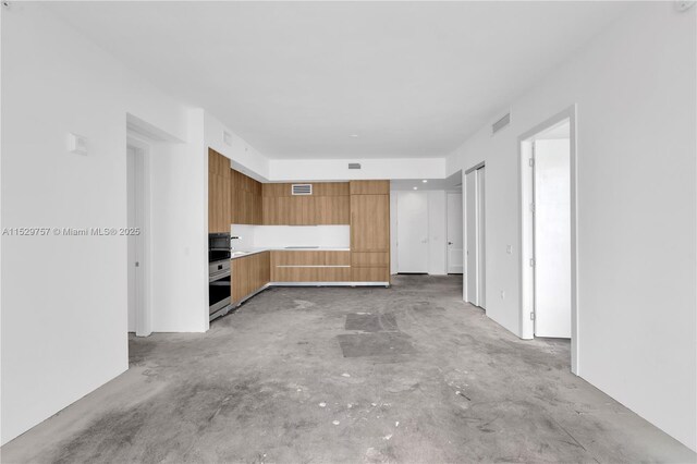 unfurnished living room featuring concrete floors