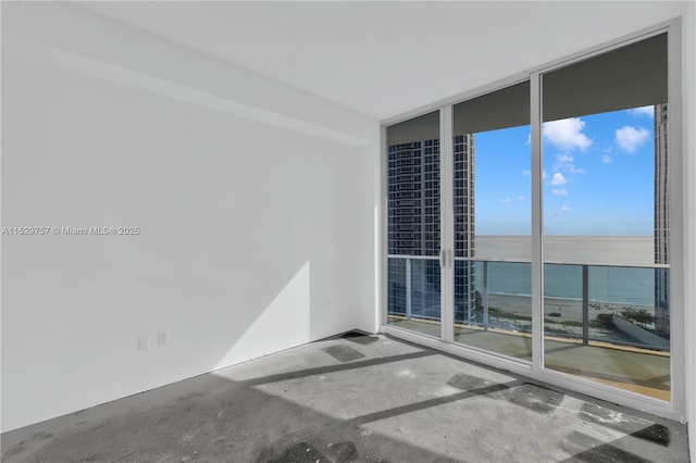 empty room featuring expansive windows and a water view