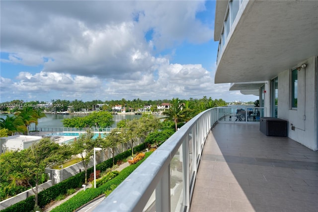 balcony featuring a fenced in pool and a water view