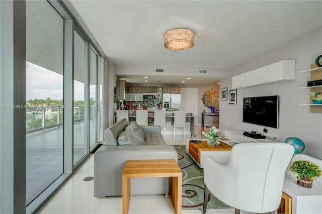 tiled living room featuring floor to ceiling windows