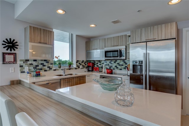 kitchen featuring backsplash, stainless steel appliances, and sink