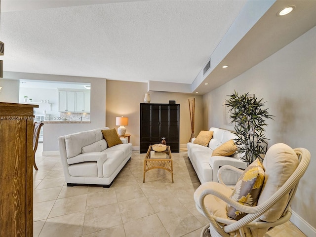 living room with a textured ceiling and light tile flooring