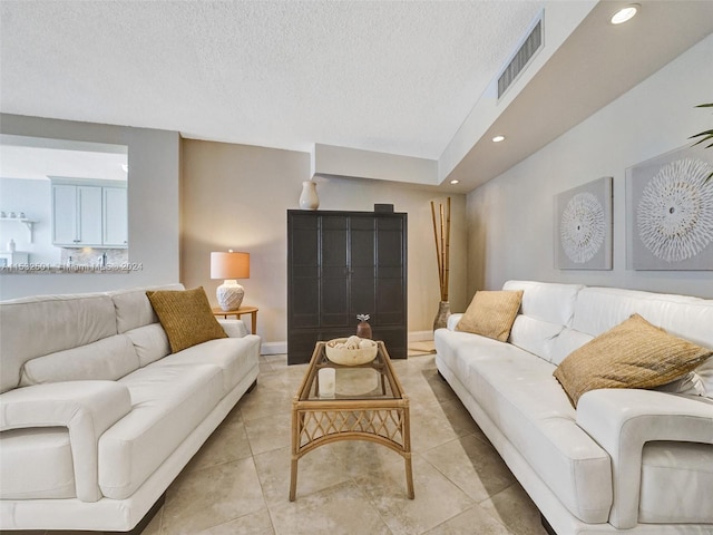 tiled living room featuring a textured ceiling