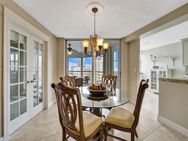 tiled dining space featuring a textured ceiling, french doors, and ceiling fan with notable chandelier