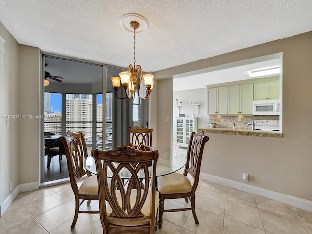 dining area featuring light tile floors, a textured ceiling, and ceiling fan with notable chandelier