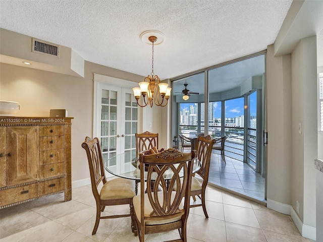 dining area featuring french doors, a textured ceiling, light tile flooring, and ceiling fan with notable chandelier