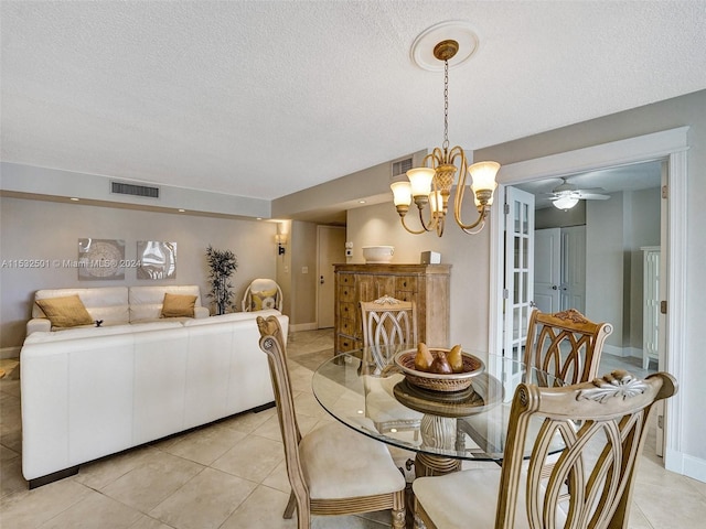 dining area with light tile floors, a textured ceiling, and ceiling fan with notable chandelier