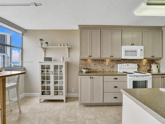 kitchen featuring white appliances, a textured ceiling, tasteful backsplash, and light tile flooring