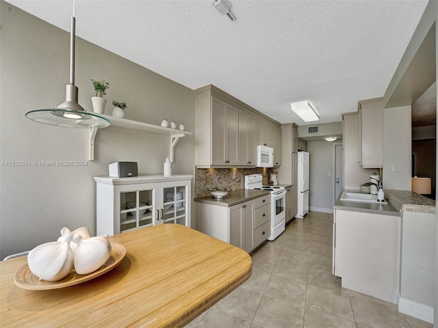 kitchen with light tile floors, a textured ceiling, white appliances, gray cabinetry, and sink