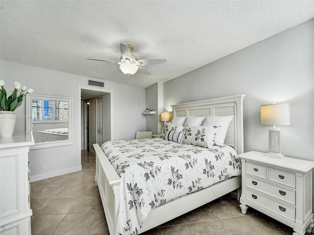 bedroom with light tile flooring, ceiling fan, and a textured ceiling