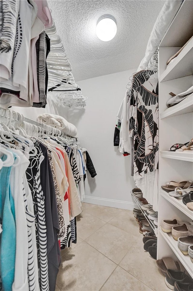 spacious closet with light tile floors