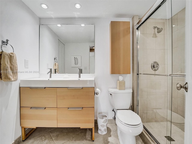 bathroom with a shower with door, tile floors, oversized vanity, and toilet