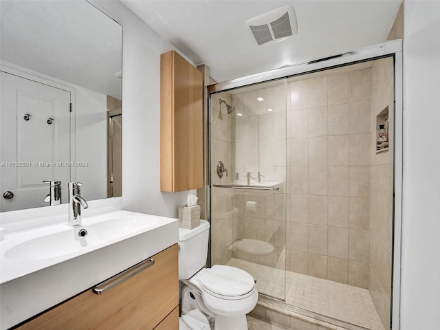 bathroom featuring an enclosed shower, oversized vanity, and toilet