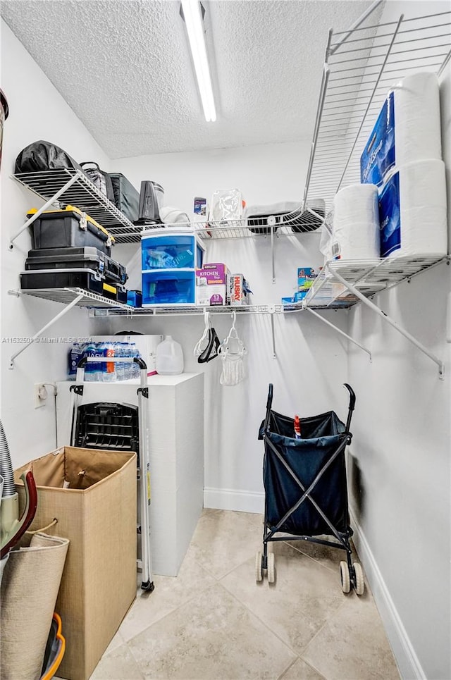 walk in closet featuring light tile floors