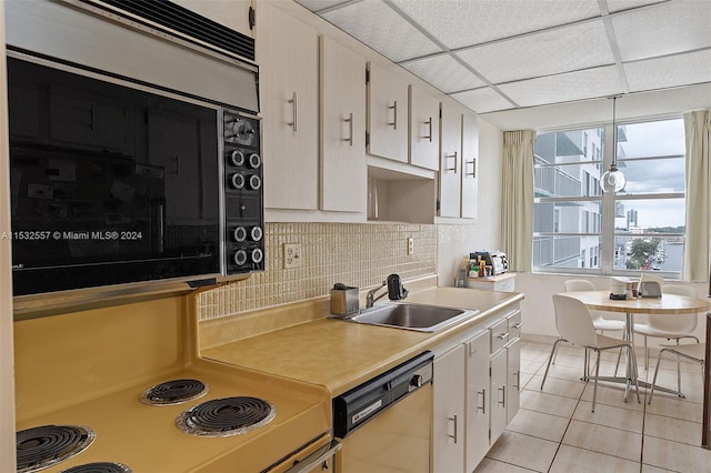 kitchen featuring light tile floors, a drop ceiling, dishwashing machine, tasteful backsplash, and sink