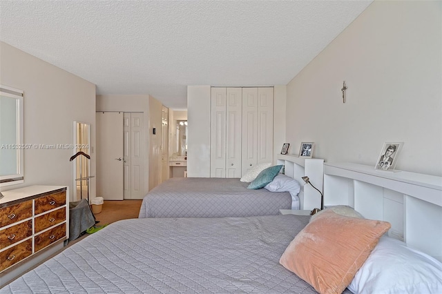 bedroom with multiple closets, carpet flooring, and a textured ceiling