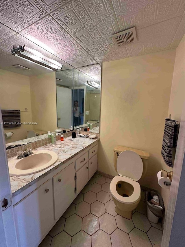 bathroom featuring vanity, tile patterned flooring, and toilet