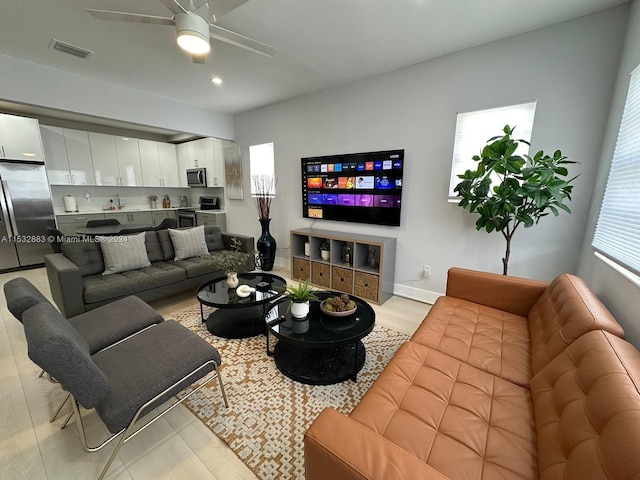 living room with ceiling fan and light hardwood / wood-style flooring