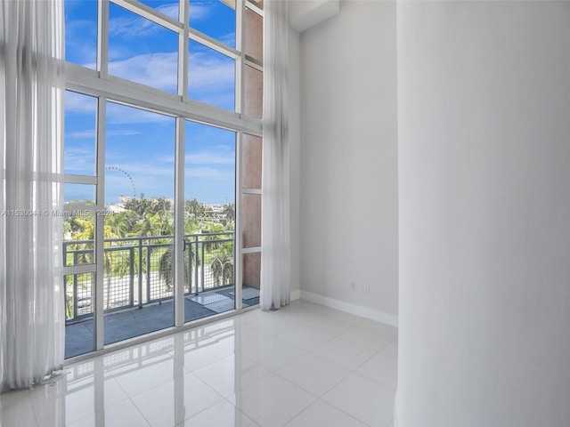 empty room featuring expansive windows and light tile floors