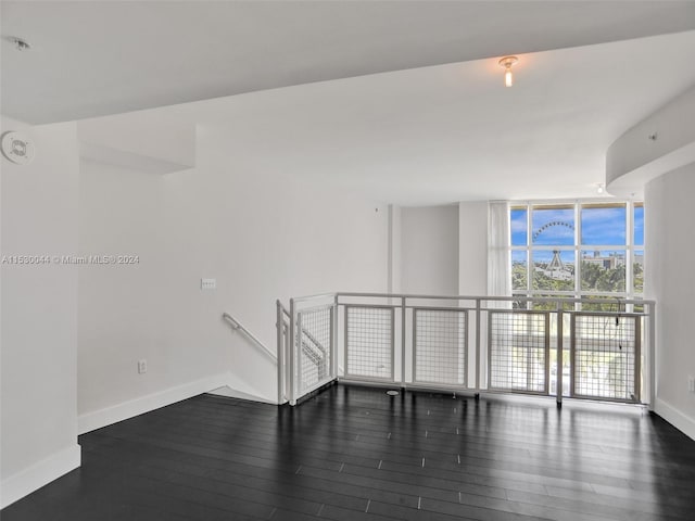 spare room with expansive windows and dark hardwood / wood-style floors