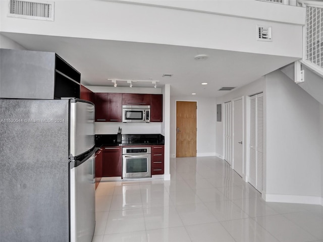 kitchen with track lighting, stainless steel appliances, and light tile floors