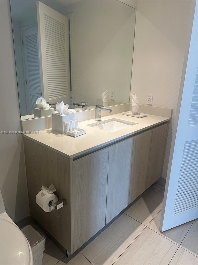 bathroom featuring toilet, tile floors, and oversized vanity