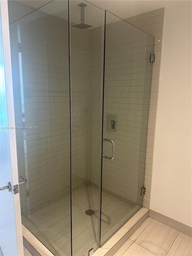 bathroom with walk in shower and tile flooring