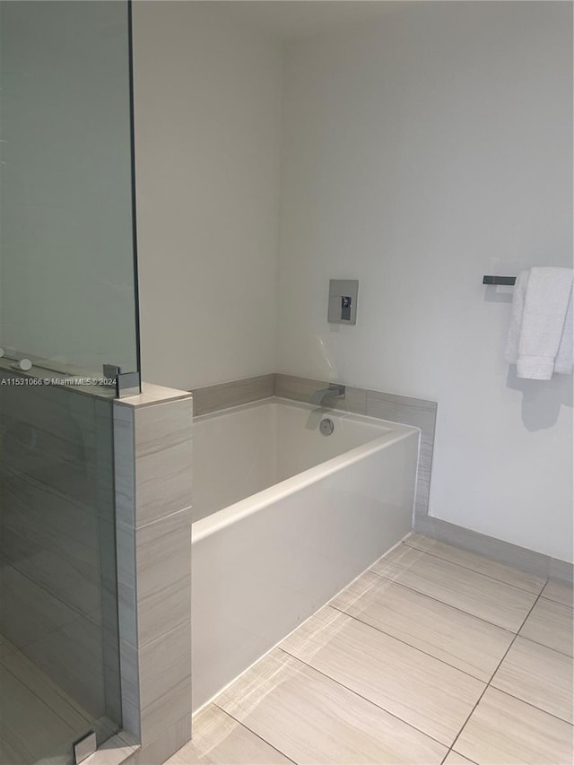 bathroom with a washtub and tile floors