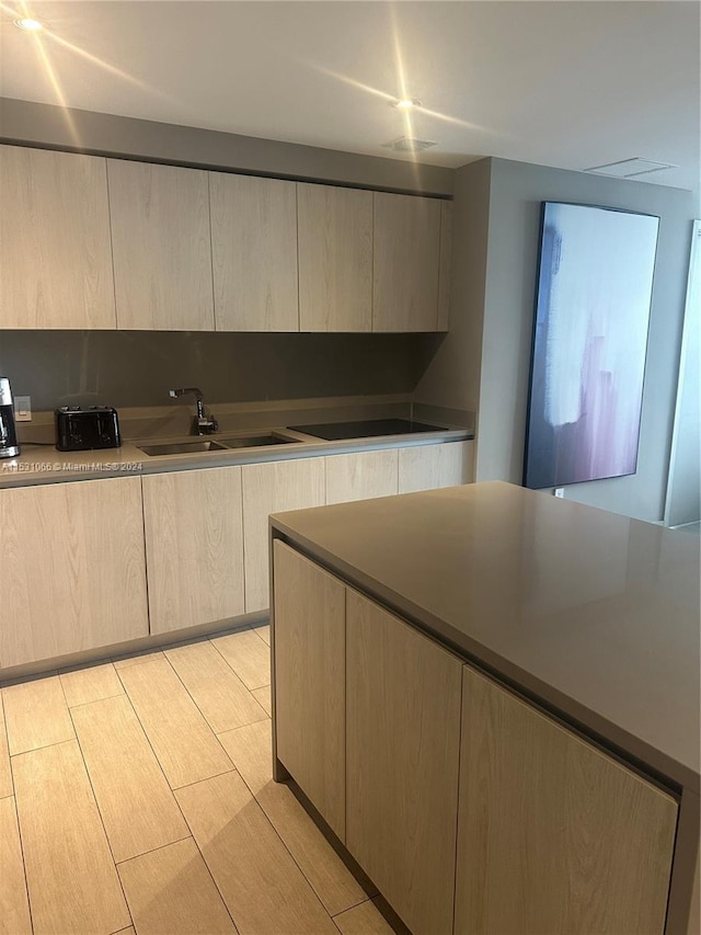 kitchen featuring light hardwood / wood-style floors, light brown cabinets, and sink