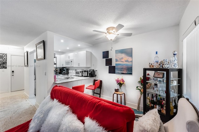 living room featuring ceiling fan and a textured ceiling