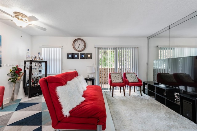 living room with ceiling fan and a textured ceiling