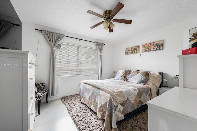 bedroom with ceiling fan and a textured ceiling