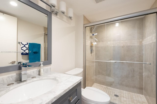 bathroom featuring walk in shower, vanity, and toilet