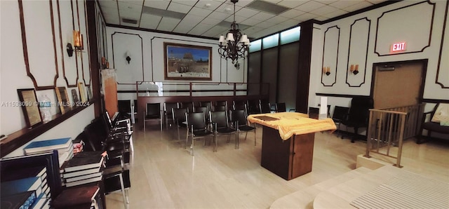 recreation room featuring a notable chandelier and a drop ceiling