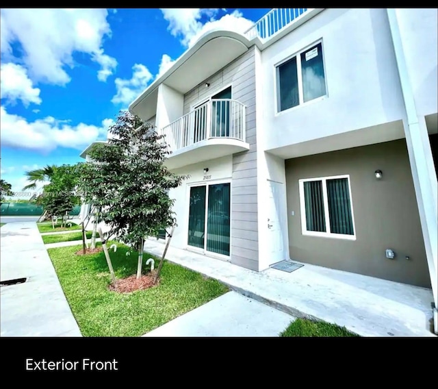 exterior space featuring a balcony and a yard