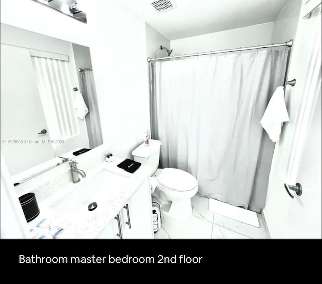 bathroom featuring toilet, tile flooring, and vanity