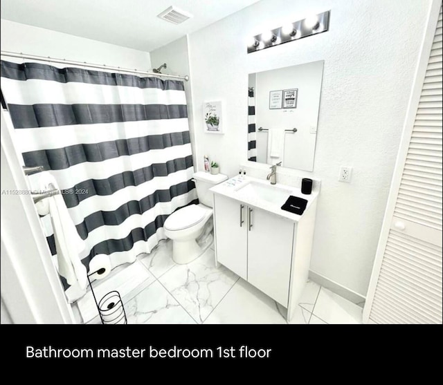 bathroom with toilet, tile flooring, and oversized vanity