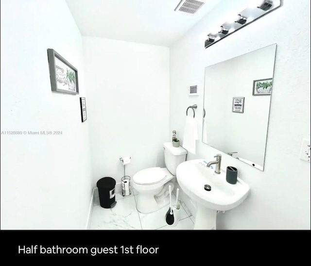 bathroom featuring sink, tile floors, and toilet