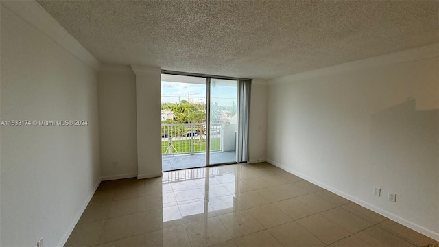 tiled spare room with floor to ceiling windows and a textured ceiling