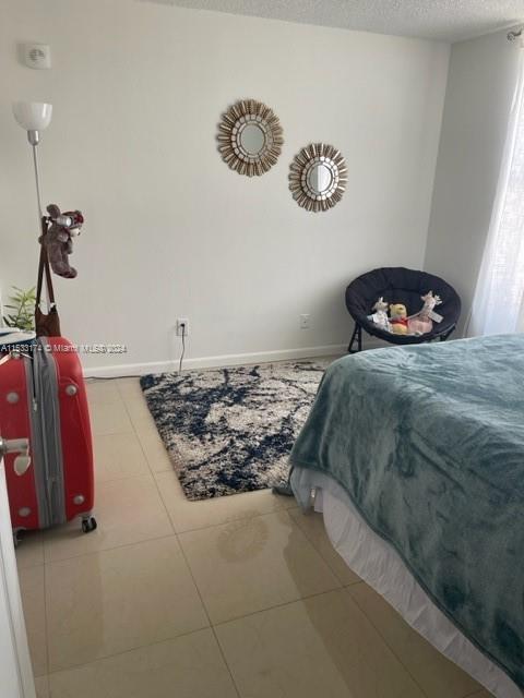 tiled bedroom featuring a textured ceiling